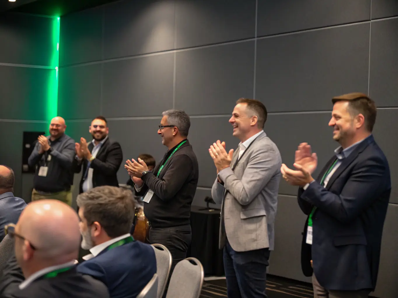 A diverse group of procurement professionals actively networking during a coffee break at the Procure.Uno conference, set against a modern conference backdrop.